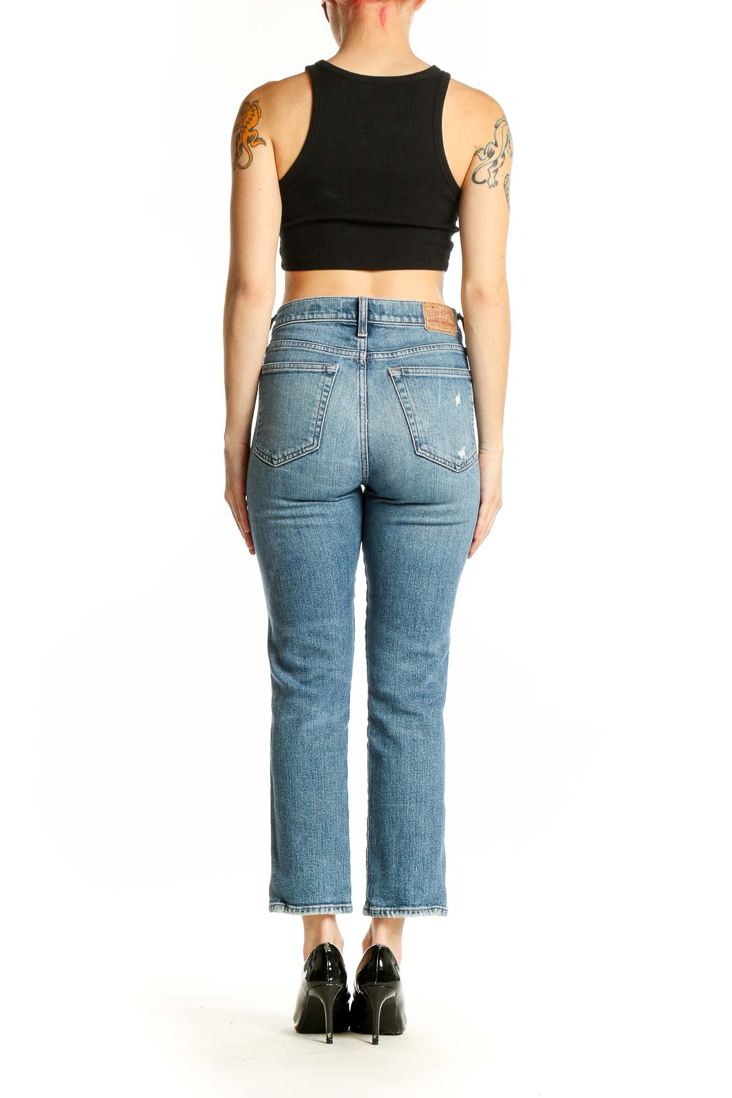 Back view of Lucky Brand light blue distressed cropped jeans on model