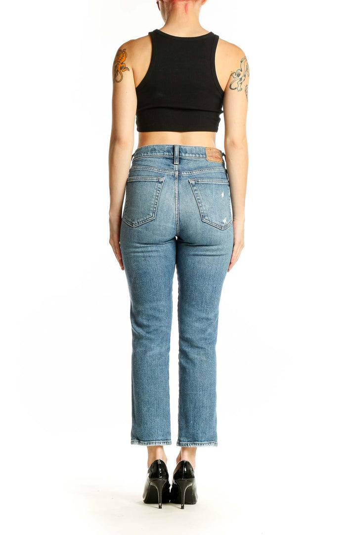 Back view of Lucky Brand light blue distressed cropped jeans on model