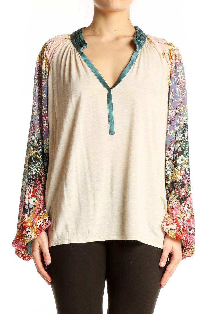 Front view of beige TINY peasant top with colorful floral print sleeves