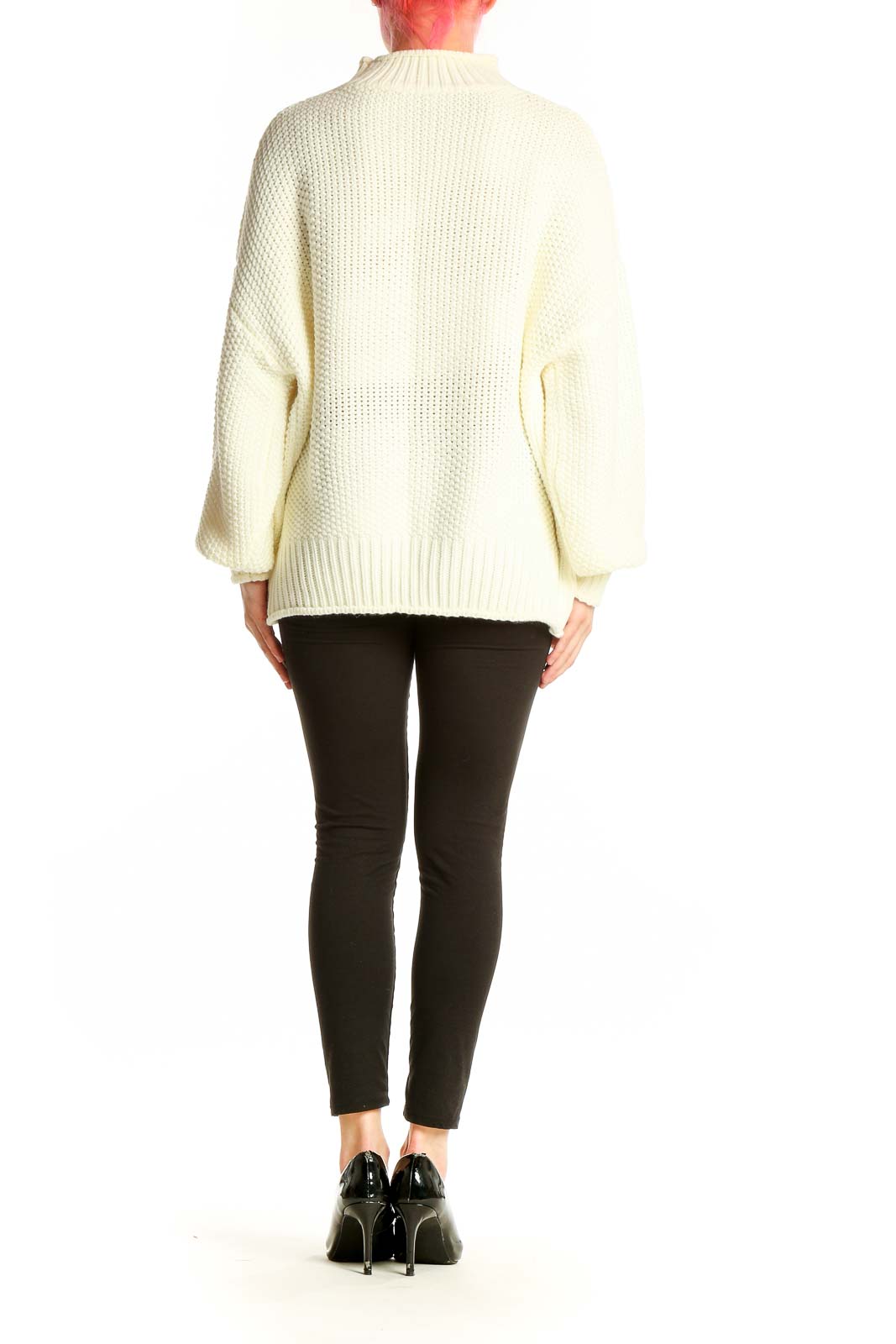 Side view of model wearing cream chunky knit sweater with black pants