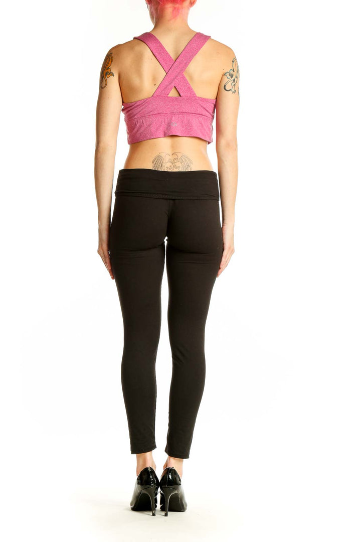 Side view of woman wearing pink GapFit sports bra with black leggings