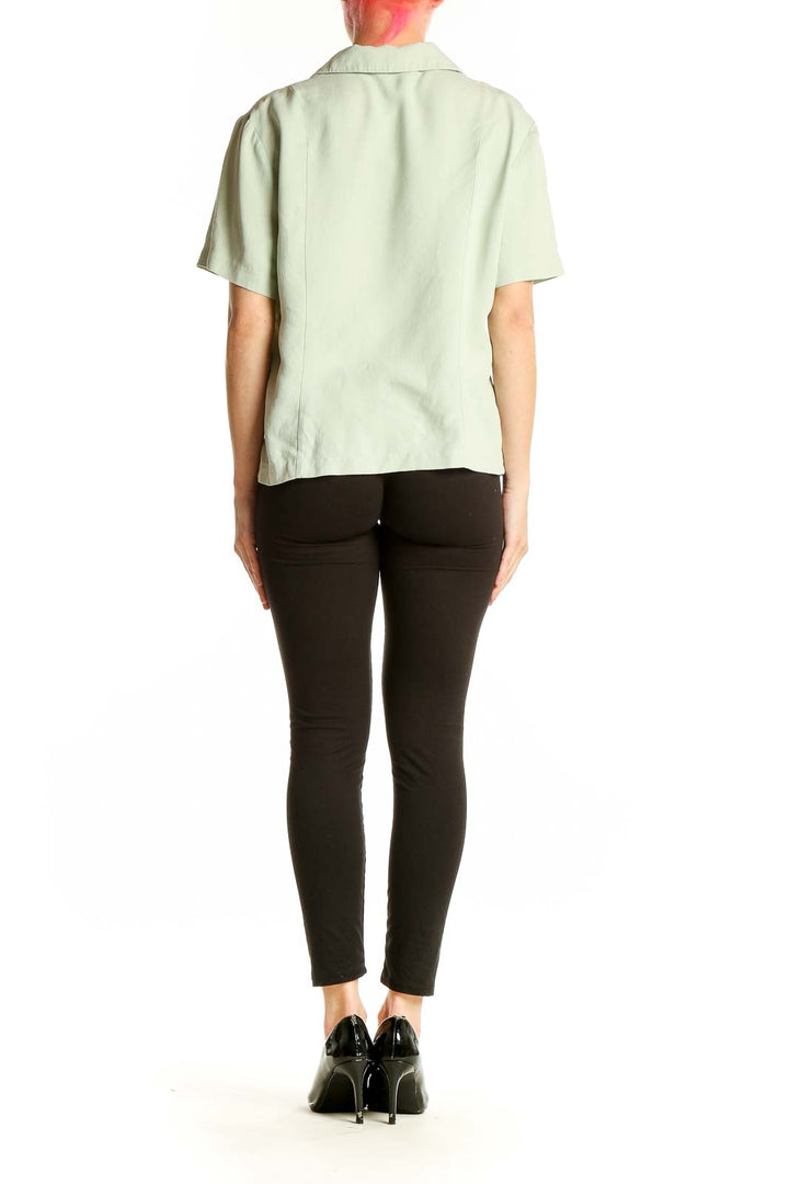 Side view of model wearing Talbots mint green silk blouse with black pants