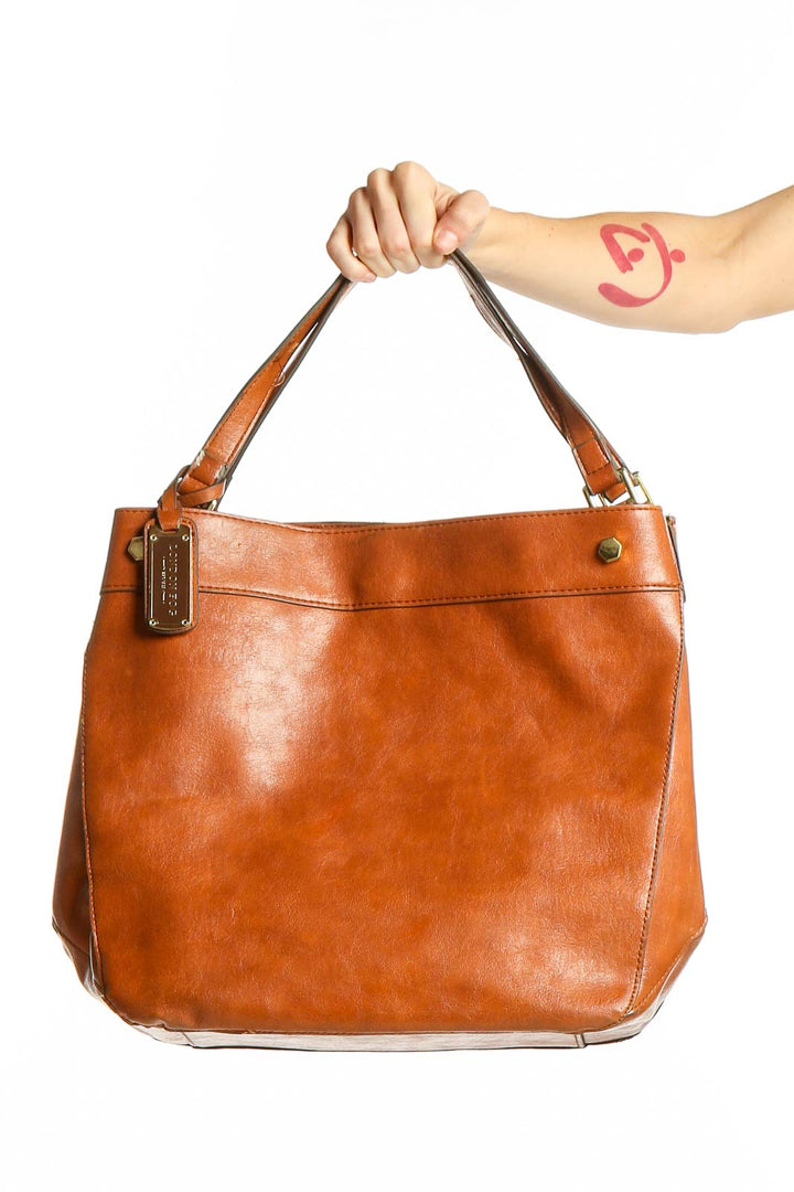 Front view of tan London Fog leather tote bag held by model's hand