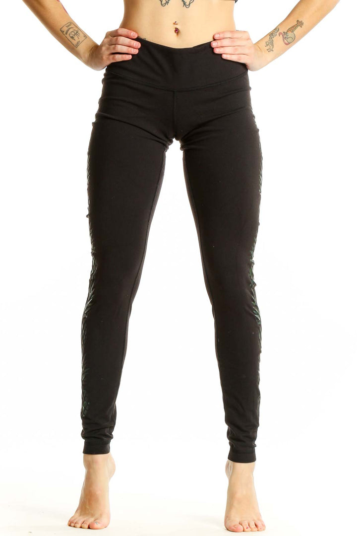 Front view of black Lululemon activewear leggings with green leaf pattern