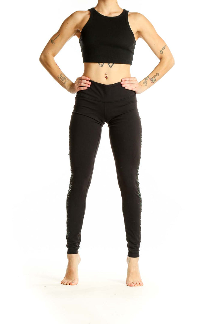Front view of black Lululemon activewear leggings with green leaf pattern