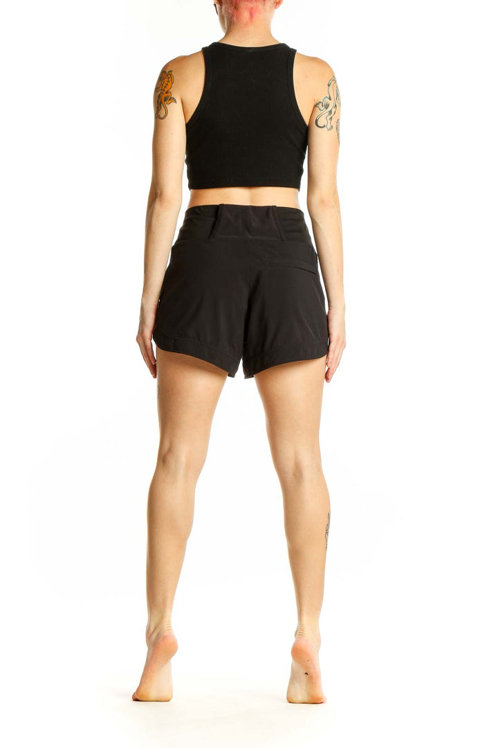 Side view of woman wearing black Athleta high-waisted athletic shorts