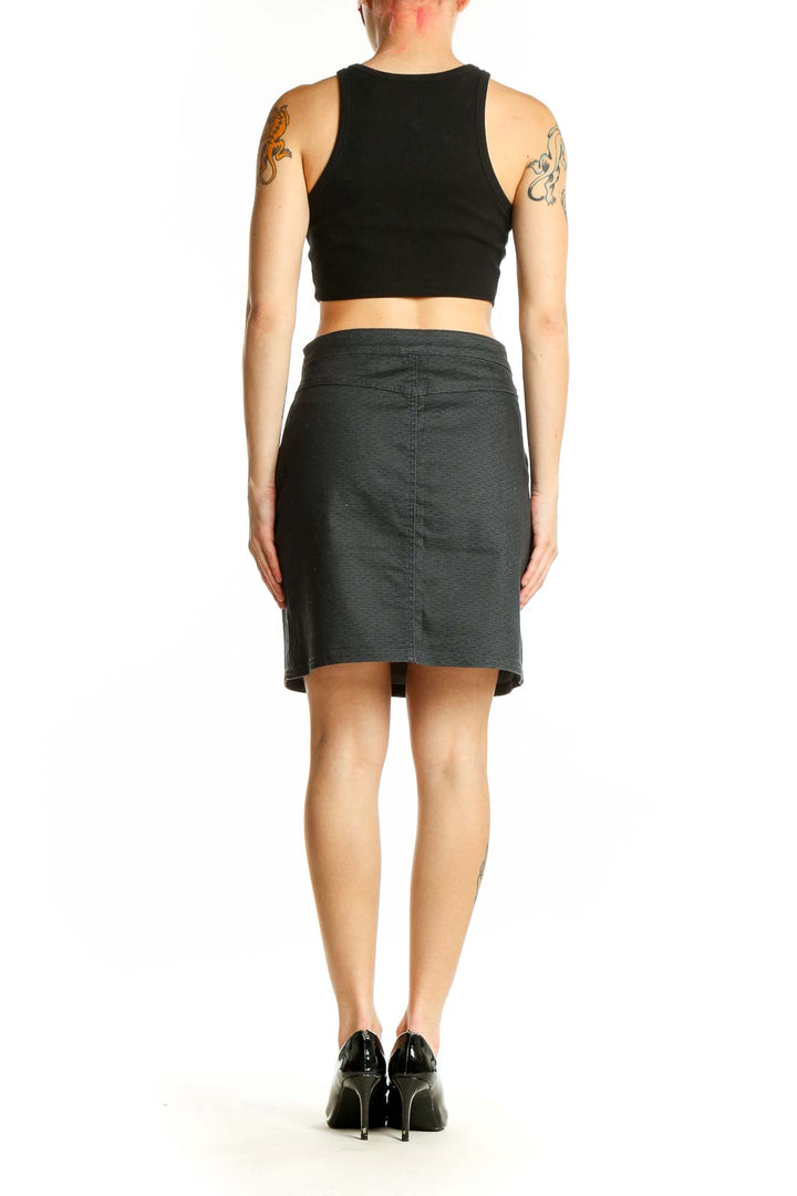 Side view of model wearing prAna charcoal textured pencil skirt with black top