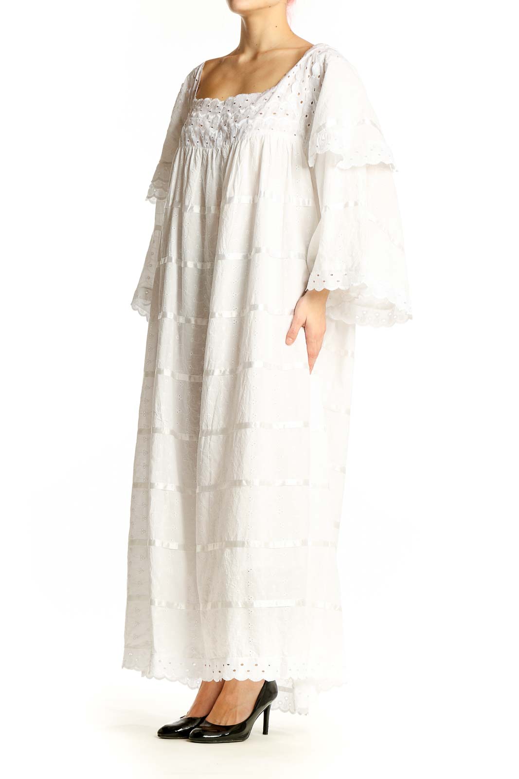 Front view of white tiered cotton maxi dress with lace details and bell sleeves