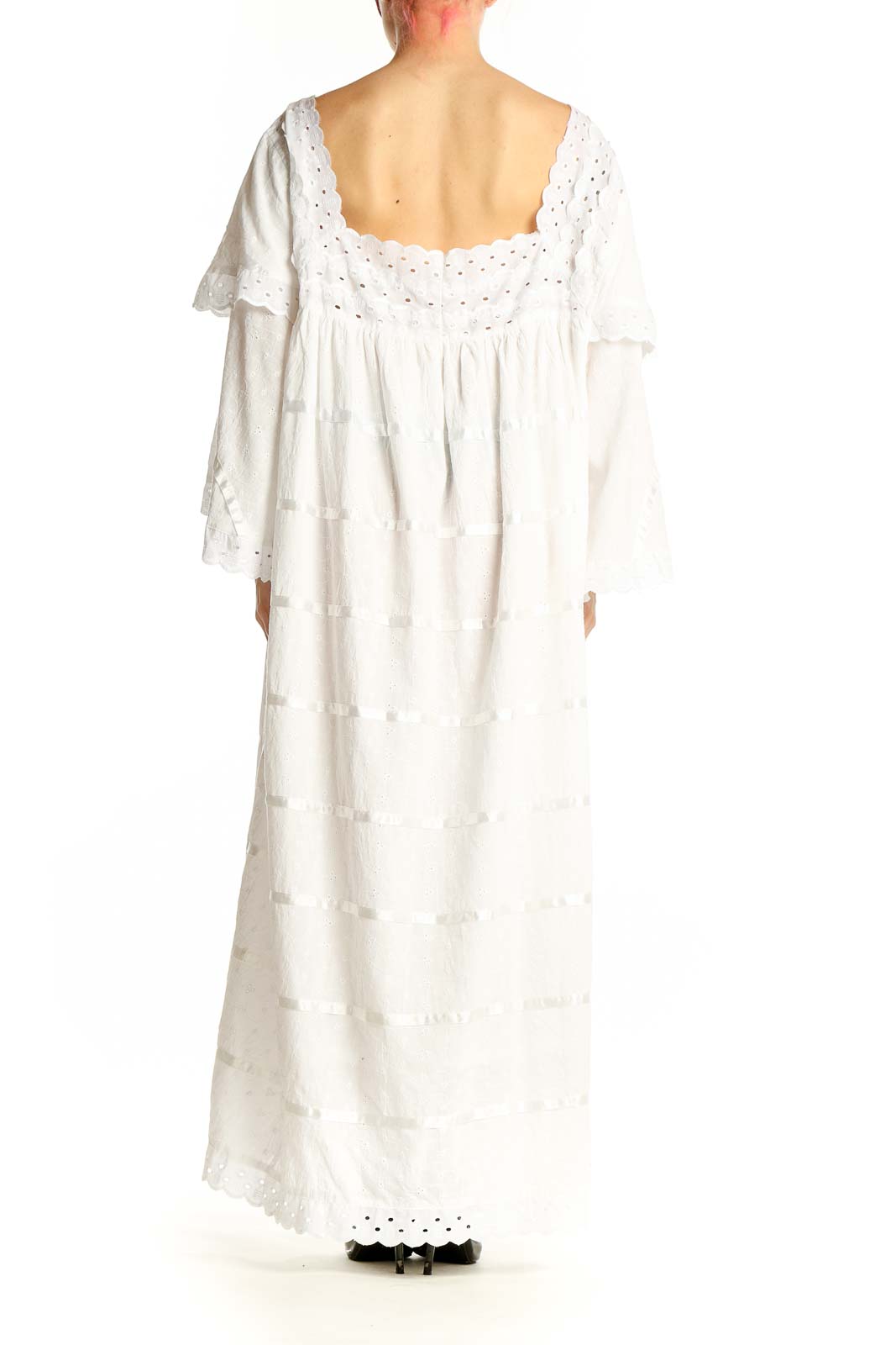 Side view of white tiered cotton maxi dress showing bell sleeves and flowing silhouette