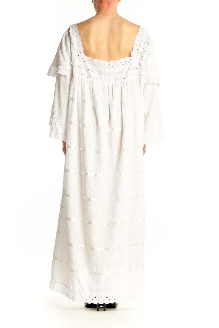Side view of white tiered cotton maxi dress showing bell sleeves and flowing silhouette