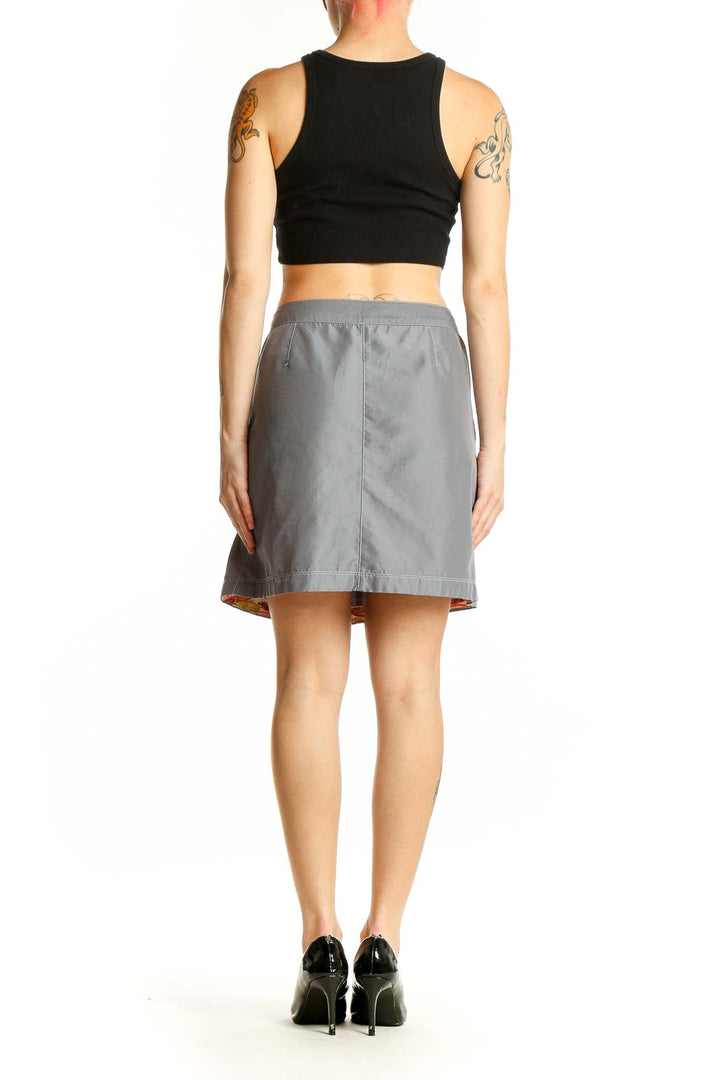 Side view of model wearing Aventura gray polyester mini skirt