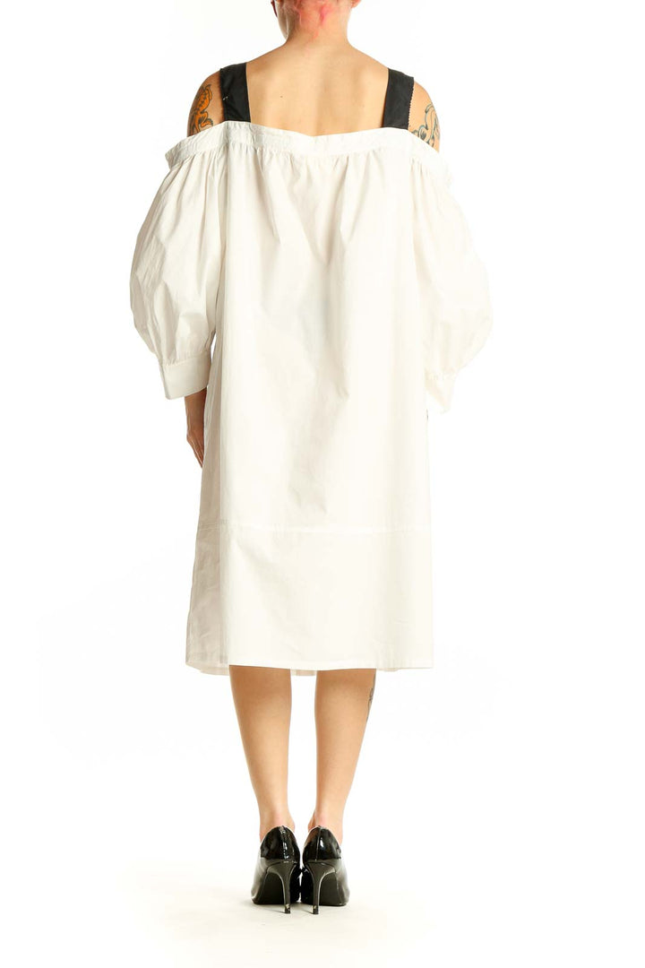 Side view of white off-shoulder cotton midi dress showing balloon sleeves