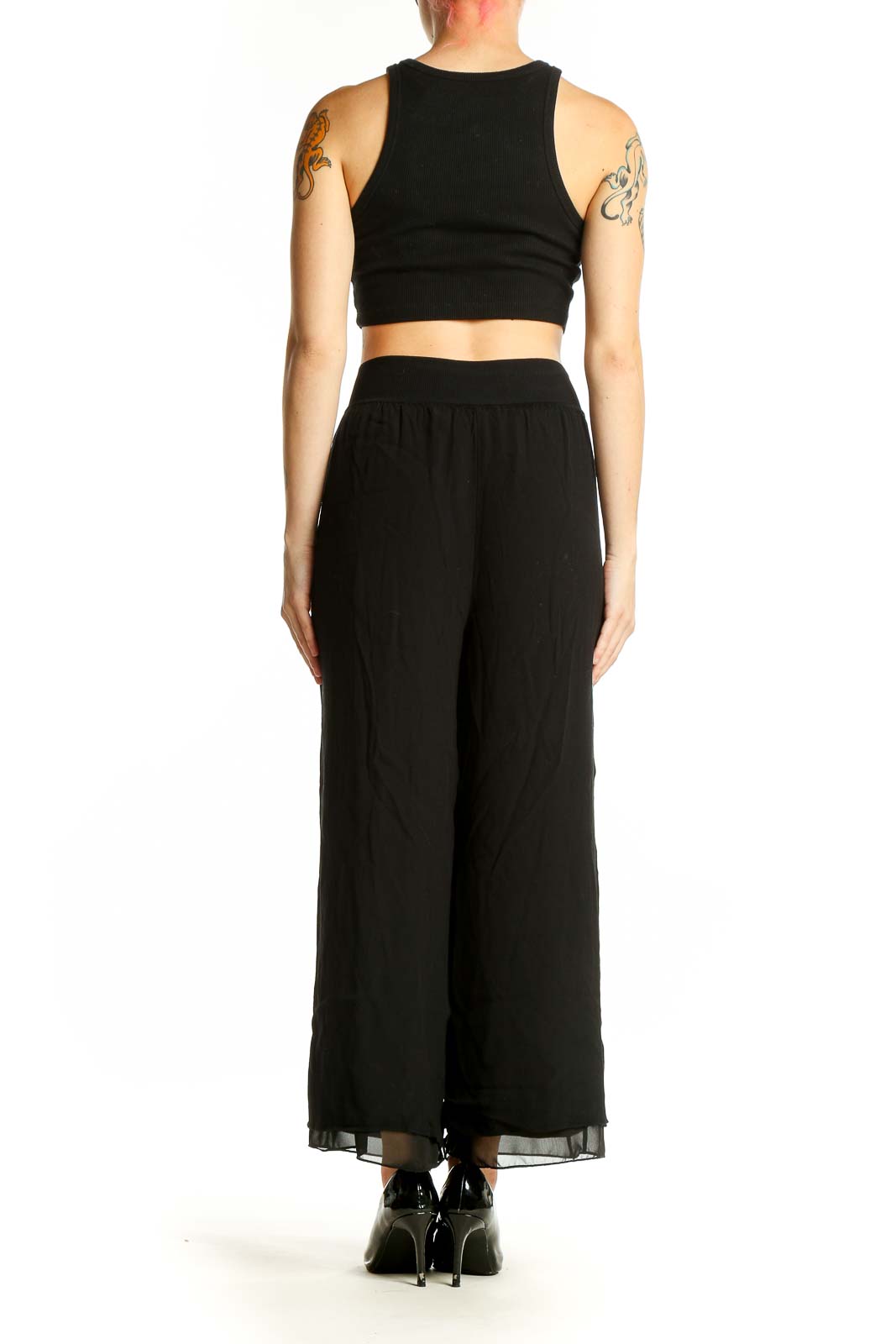 Side view of model wearing Theory black wide-leg pants with crop top