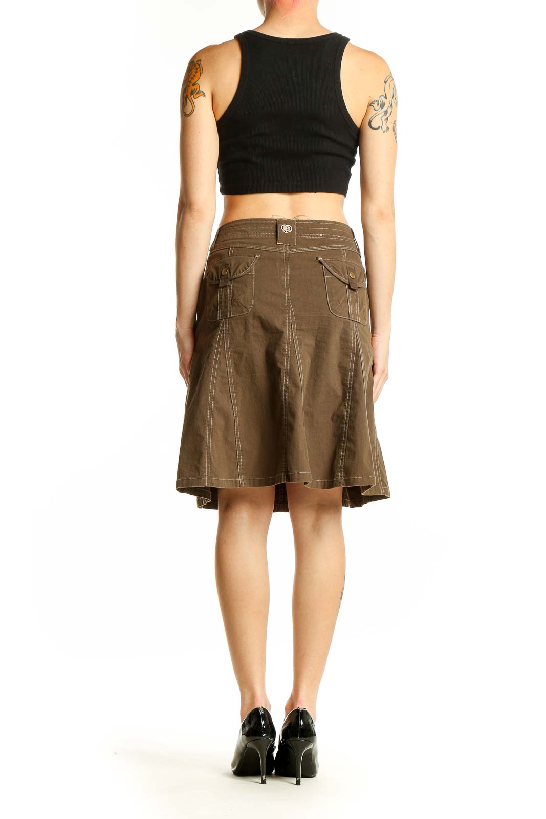 Side view of model wearing KUHL brown A-line skirt with black top