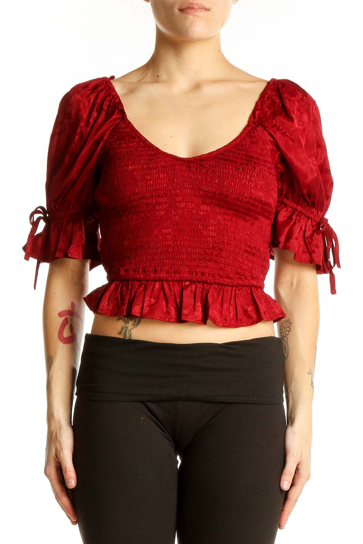Front view of red smocked crop top with puff sleeves and ruffle hem