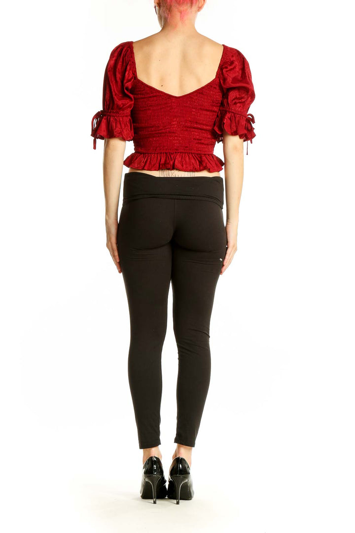 Back view of red smocked crop top showing puff sleeves and fitted waist