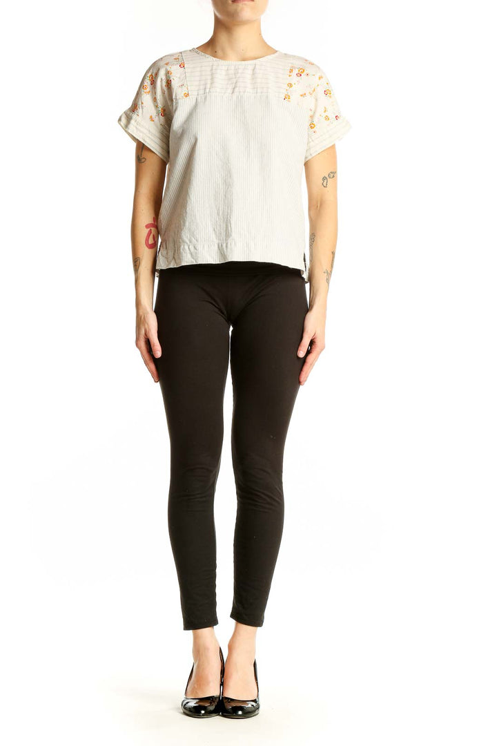 Front view of Madewell white cotton top with orange floral print on shoulders and sleeves
