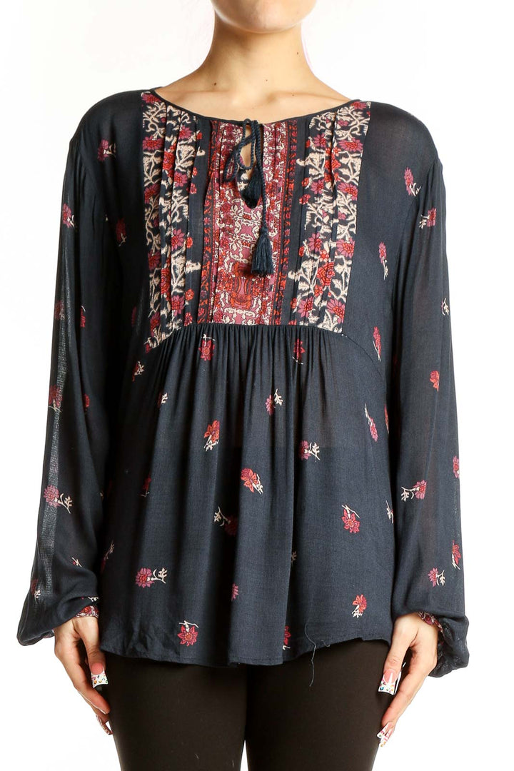 Front view of Lucky Brand black peasant blouse with red floral print and tassel tie