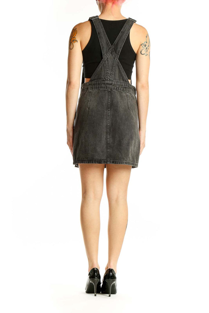 Side view of Free People charcoal denim overall mini dress showing button closures