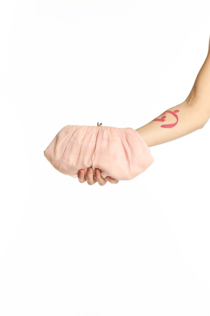 Front view of SilkRoll pink pleated clutch purse held in hand
