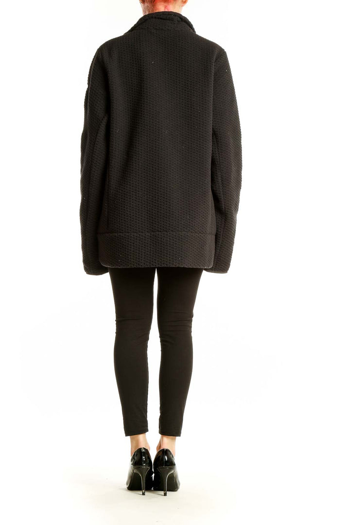 Side view of black textured Helly Hansen zip-up hooded jacket on model