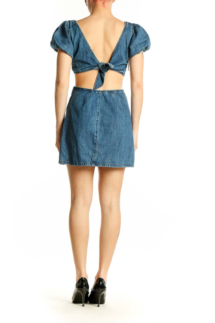 Side view of blue denim mini dress showing cutout detail and fitted silhouette