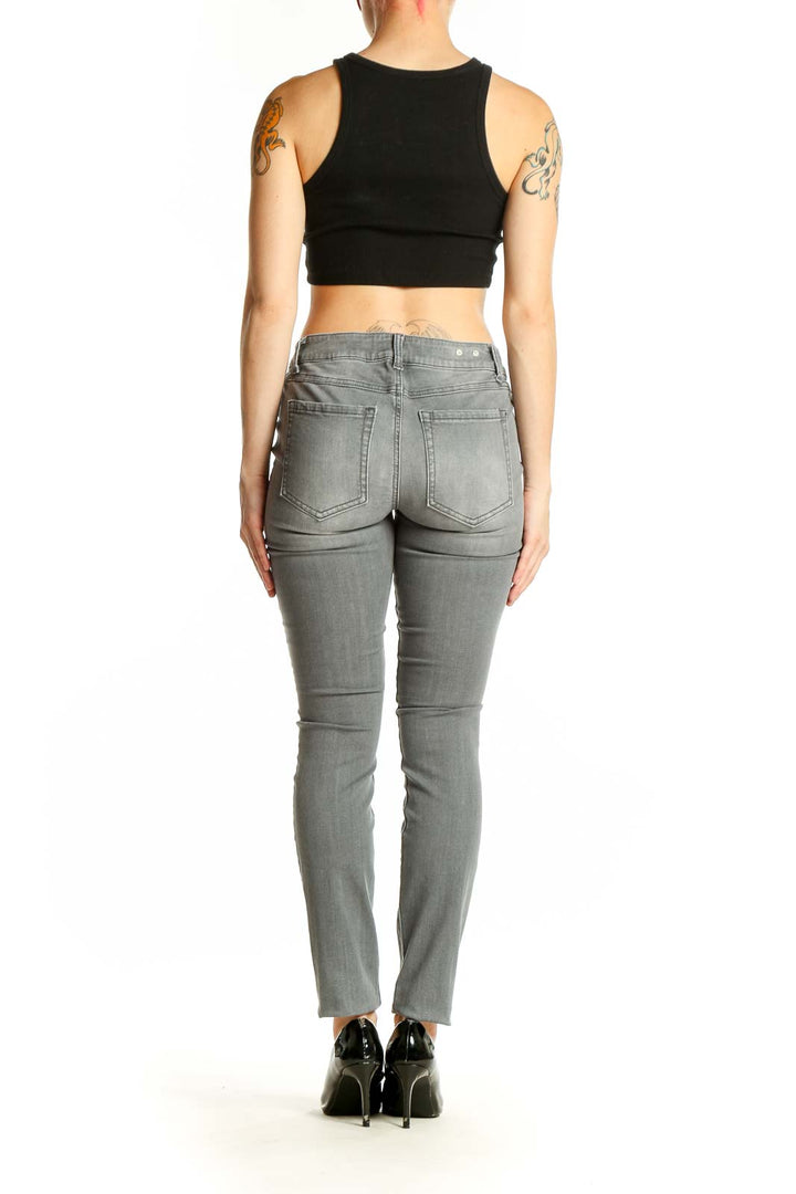 Side view of woman wearing Cabi gray skinny jeans and black crop top