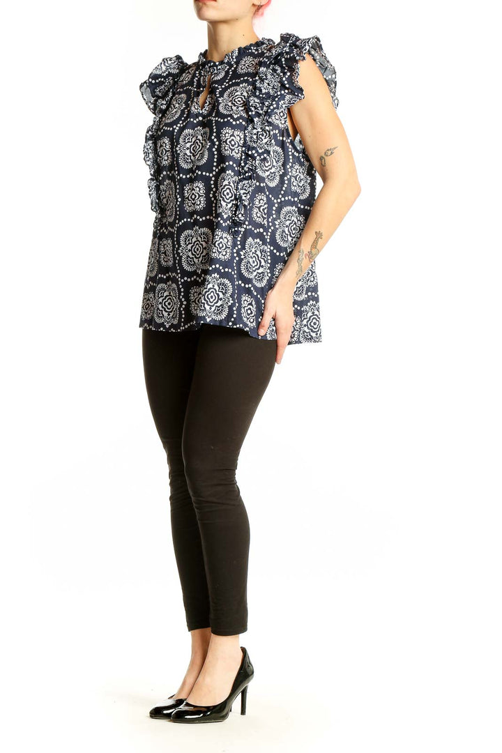Front view of Ann Taylor navy blouse with white floral print and ruffle sleeves