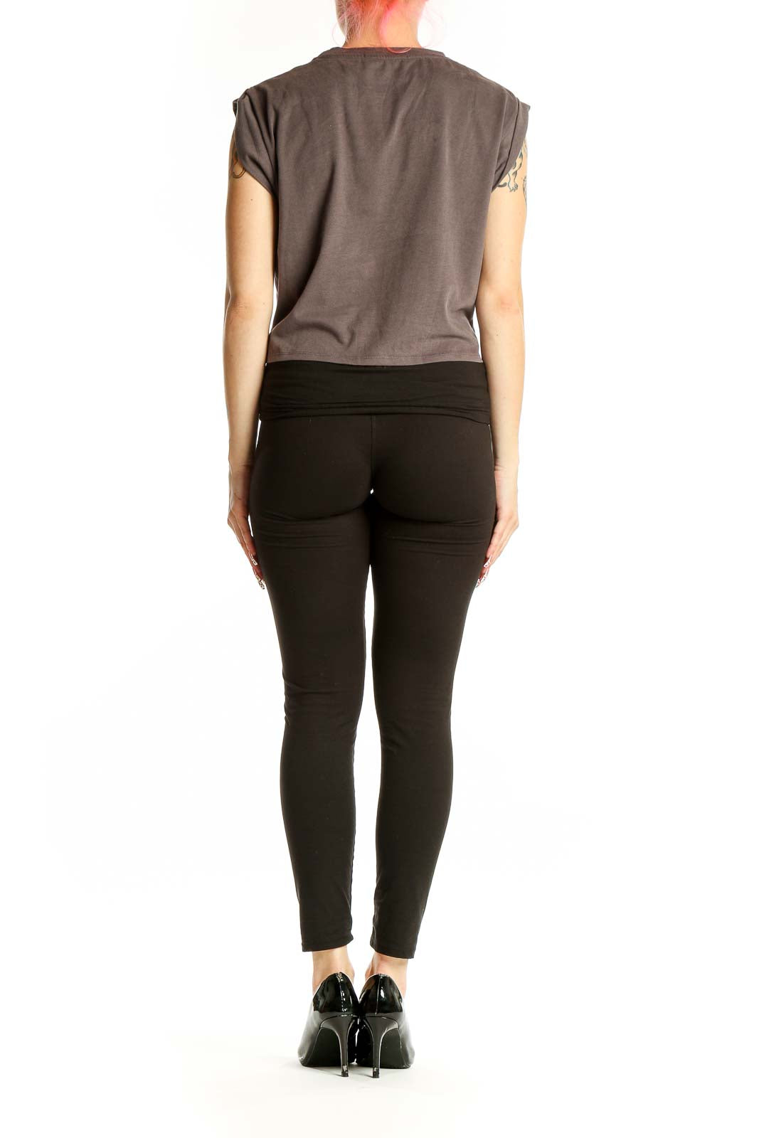 Side view of model wearing gray Cider crop top with black pants and heels