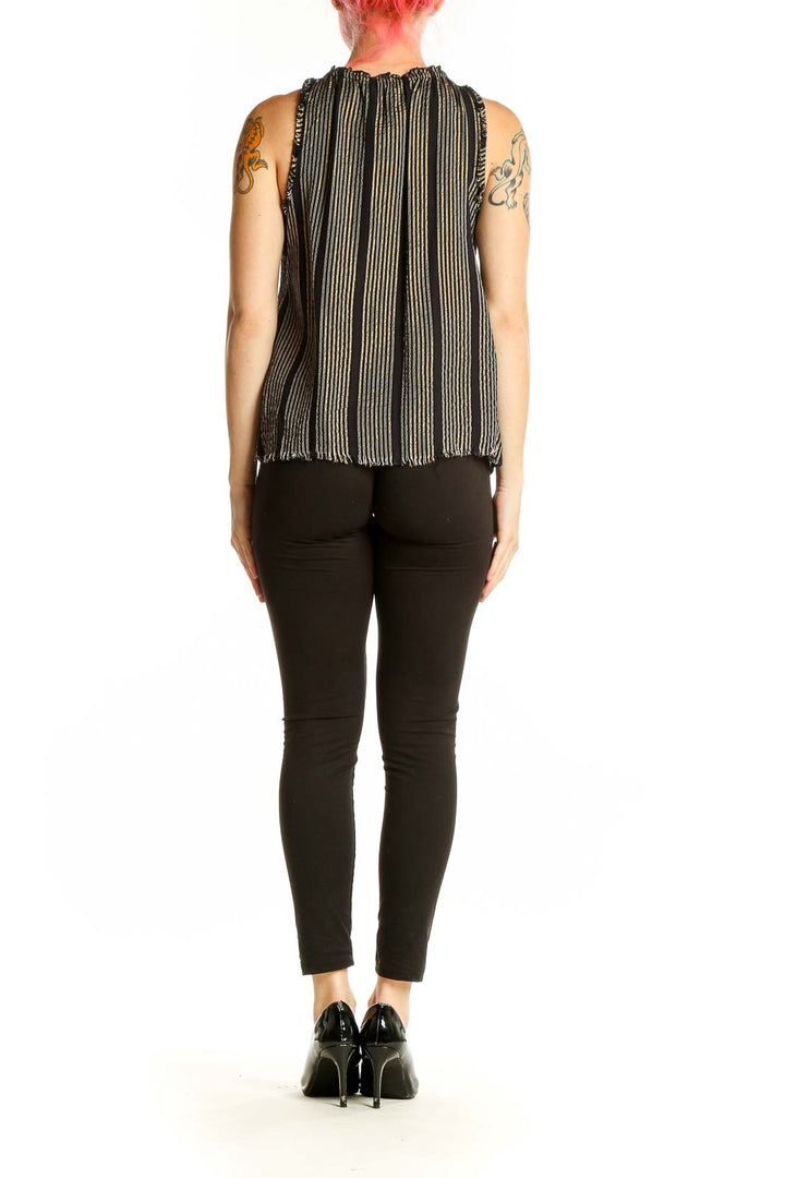 Side view of Apiece Apart black and gold striped sleeveless blouse showing flowy silhouette