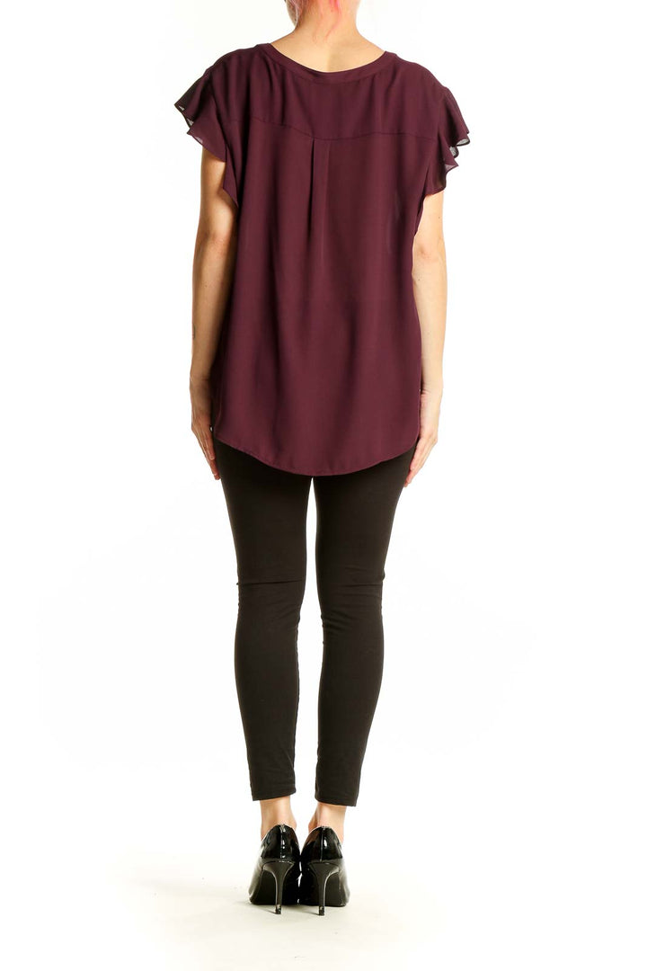 Side view of burgundy Calvin Klein blouse showing ruffled sleeves and relaxed fit