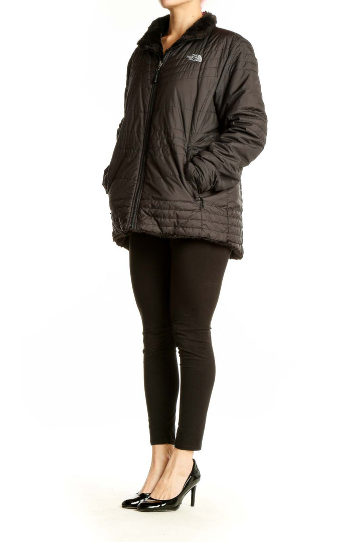 Front view of black quilted The North Face jacket with sherpa-lined collar
