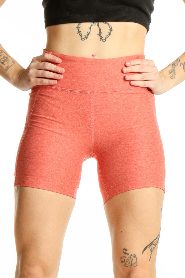 Front view of coral high-waisted workout shorts from Outdoor Voices