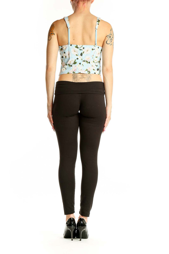 Side view of Victoria's Secret light blue floral crop tank top on model with black pants