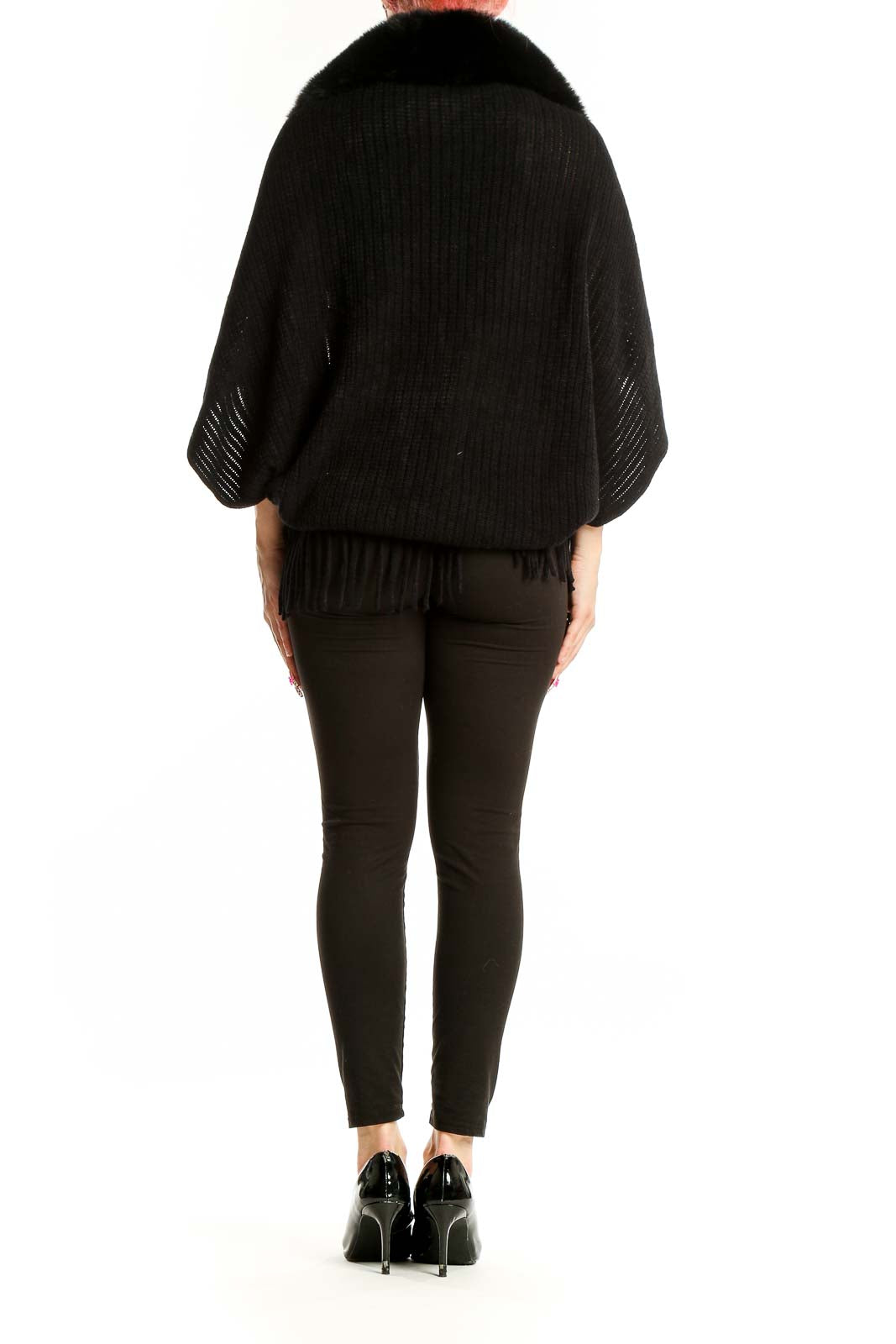 Side view of woman wearing black knit shawl with fur collar