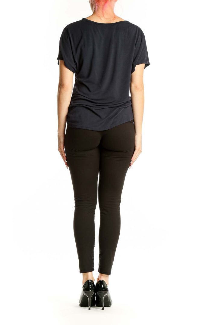 Side view of Elie Tahari black twist-front top showing drape