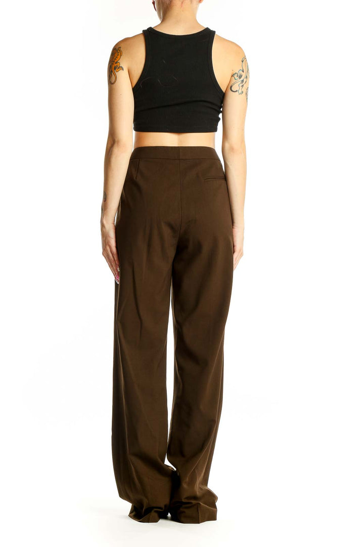 Side view of woman wearing brown wide-leg trousers with black top