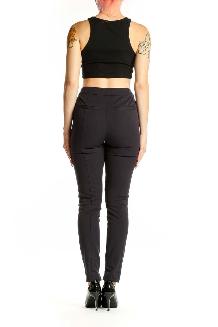 Side view of woman wearing Reiss black slim fit dress pants with crop top