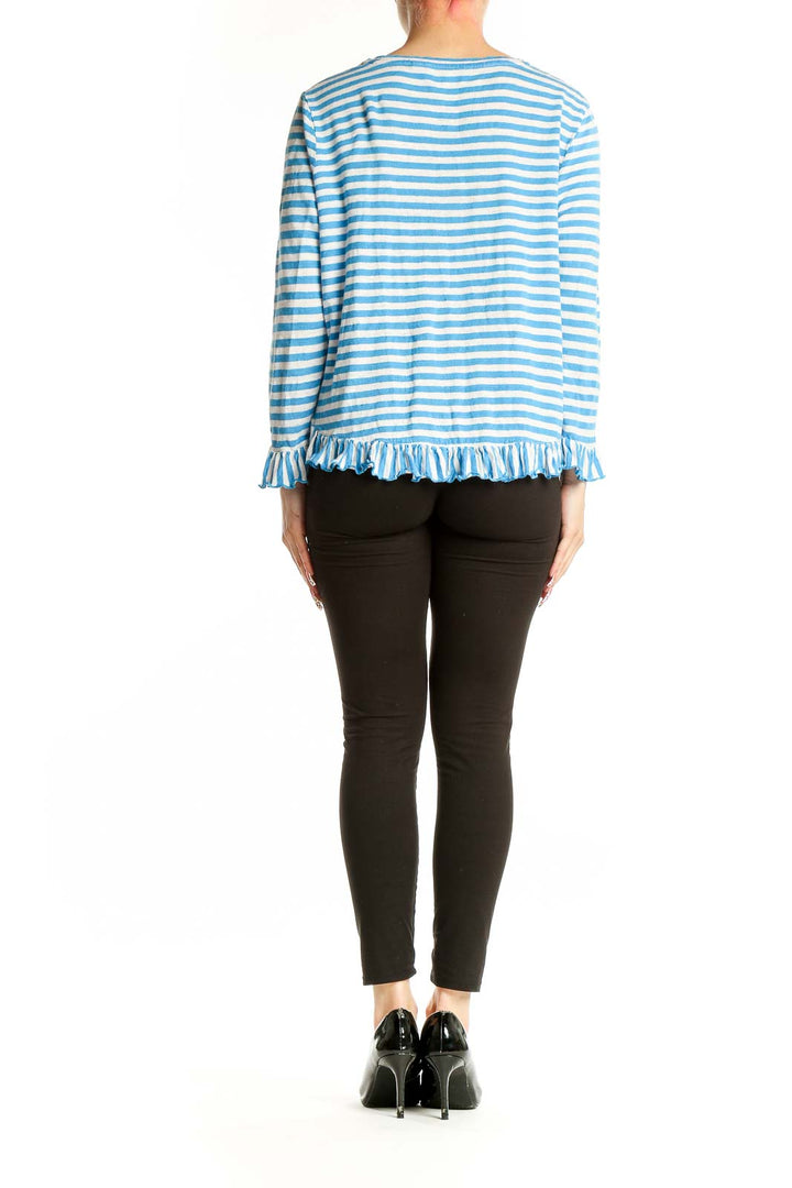 Side view of woman wearing Boden blue striped top with black pants