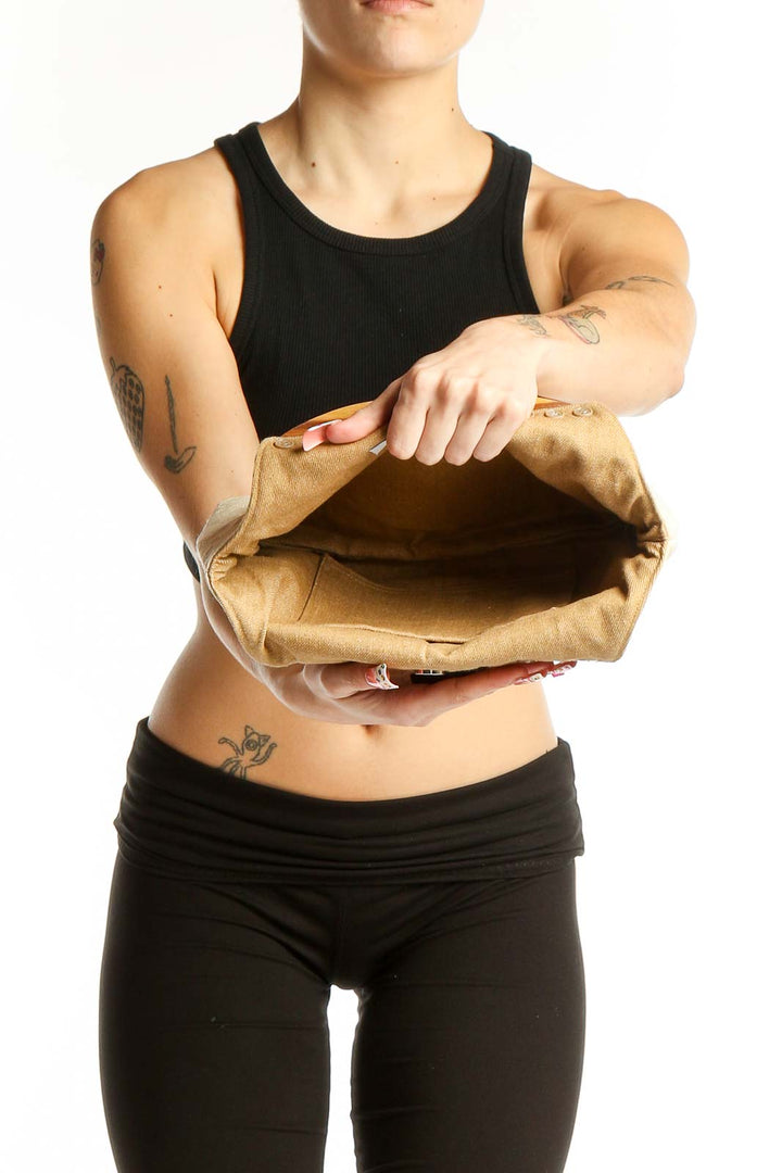 Woman holding cream SilkRoll satchel with black outfit