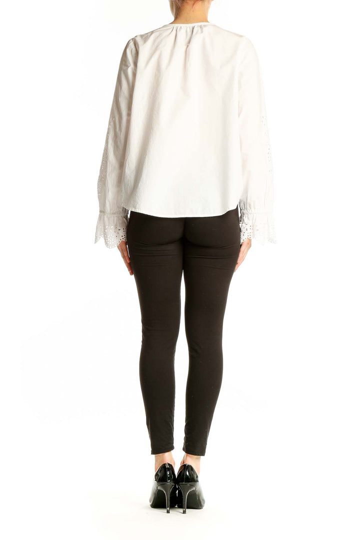Side view of Joie white blouse showcasing eyelet lace bell sleeves