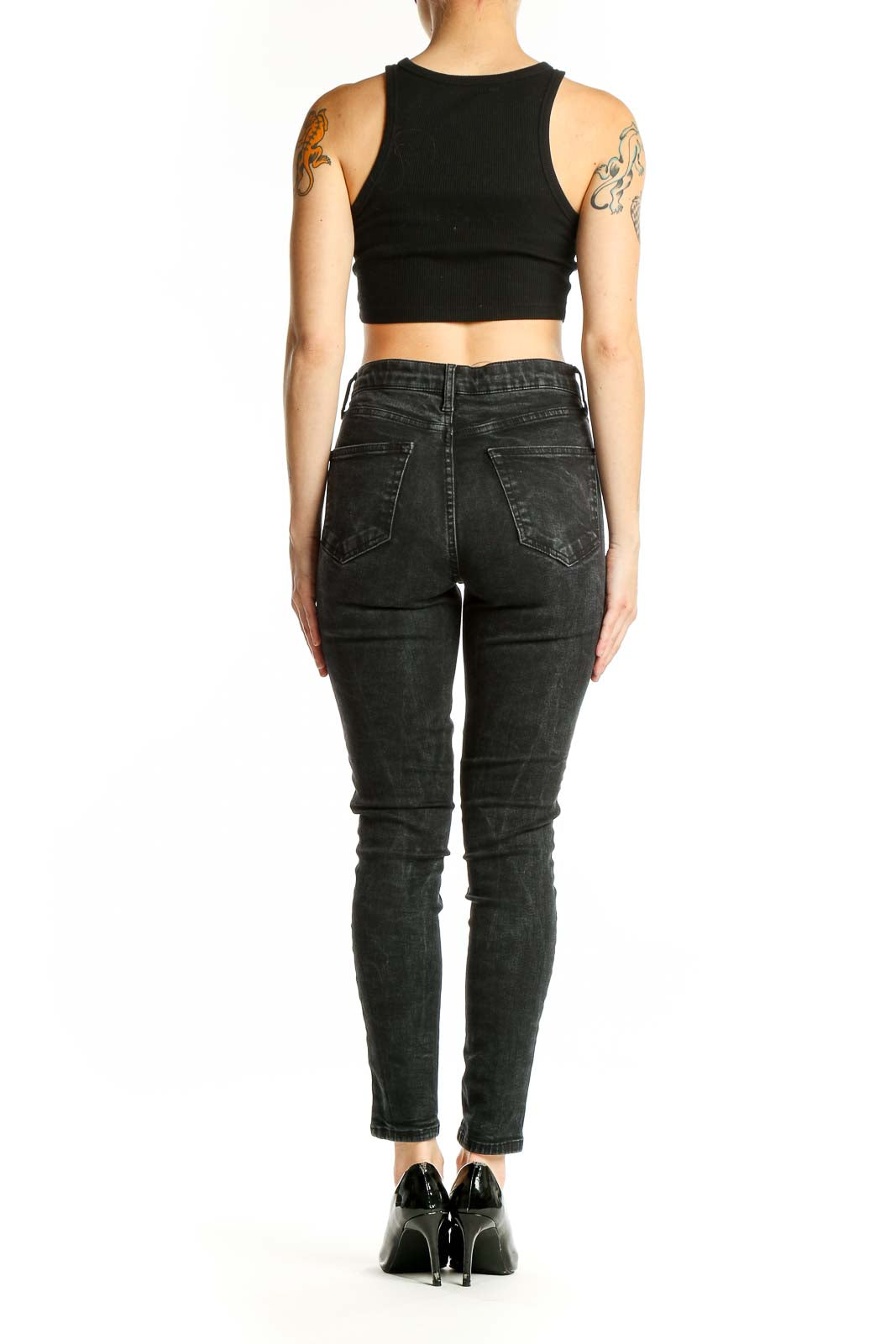 Side view of model wearing Topshop black lace-up skinny jeans with crop top