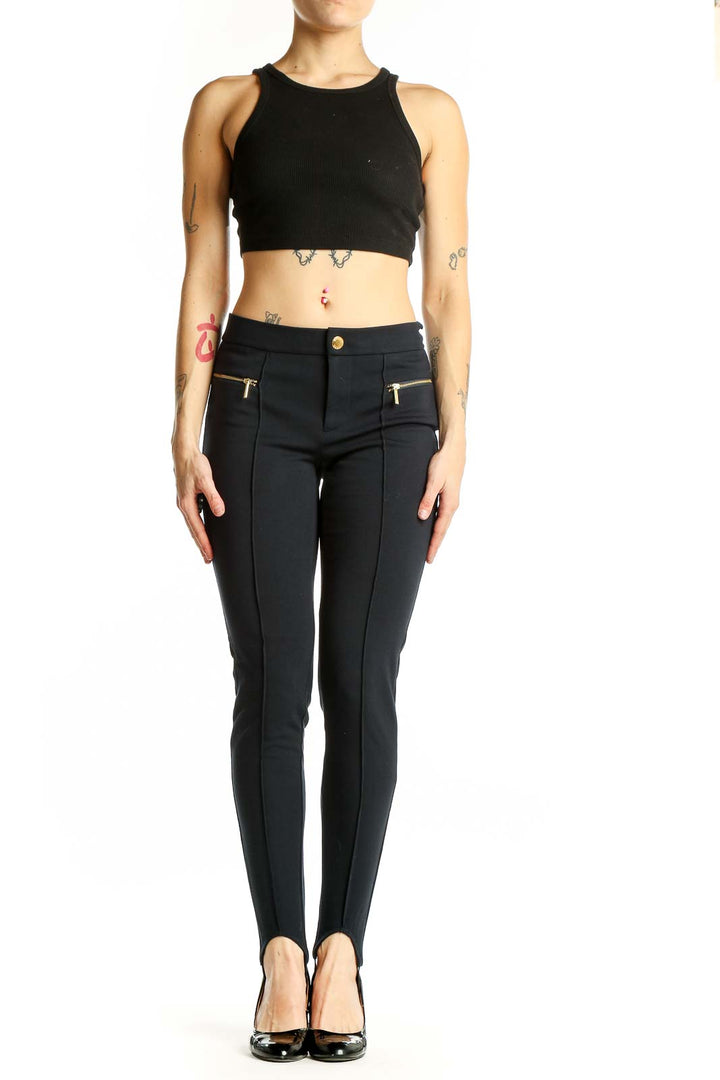 Front view of Michael Kors black stirrup pants with gold-toned zip pockets