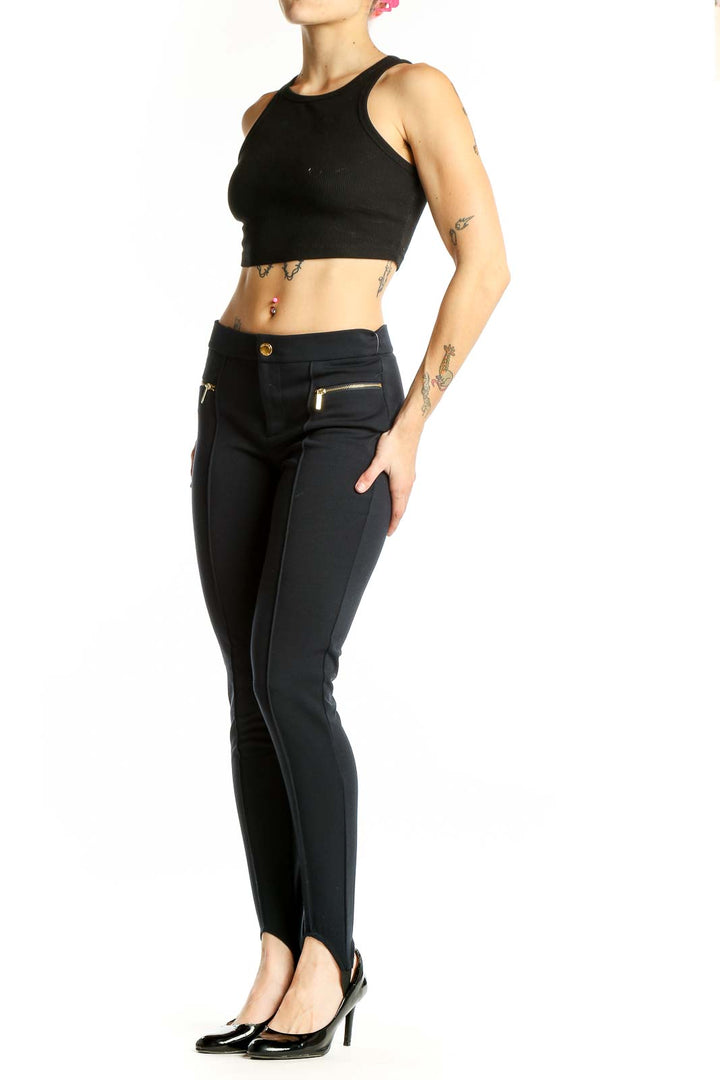 Front view of Michael Kors black stirrup pants with gold-toned zip pockets
