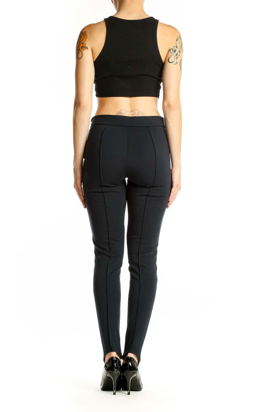 Side view of woman wearing Michael Kors black stirrup pants and crop top