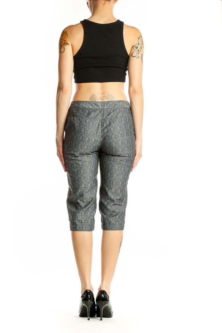 Side view of woman wearing gray pinstriped capri pants by Derek Lam