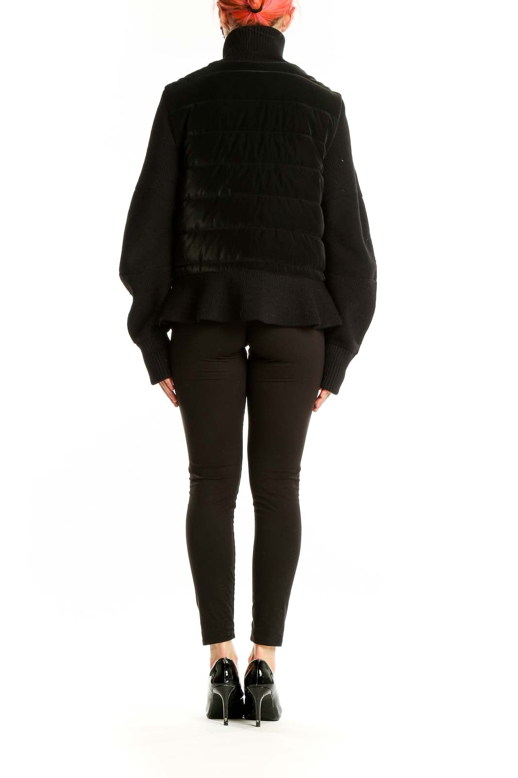 Side view of black quilted Athleta jacket showing ribbed sleeves and drawstring waist