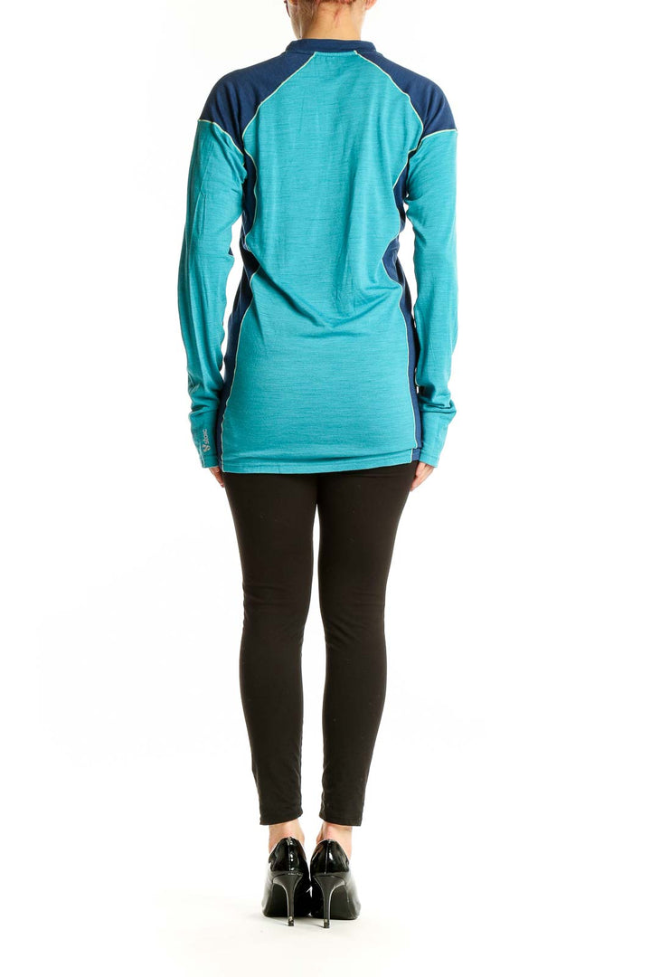 Side view of teal and navy color-block Stoic athletic top on model