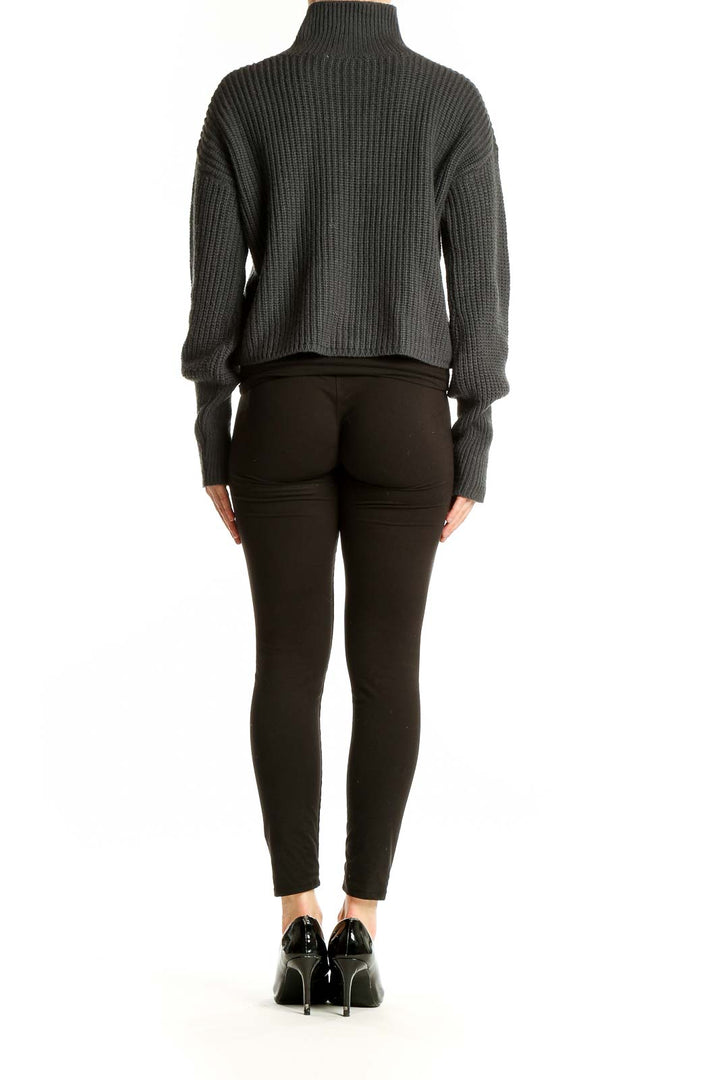 Back view of charcoal cropped turtleneck sweater on model with black pants