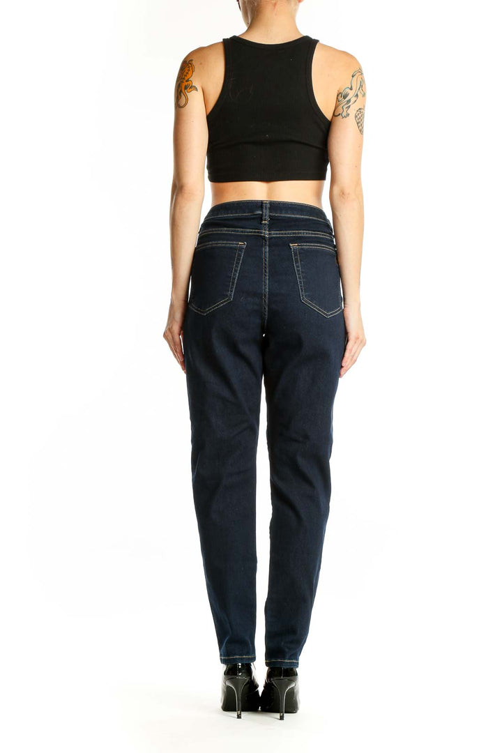 Side view of woman wearing Michael Kors dark blue high-waisted straight leg jeans